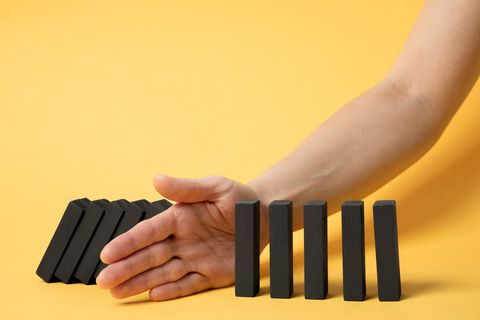 יד עוצרת שורת אבני דומינו מליפול